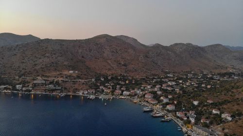 Aerial view of townscape by sea against clear sky