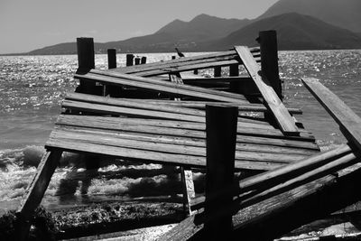 Empty bench by lake against mountains