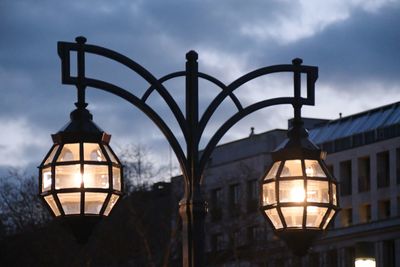 Low angle view of illuminated street light against sky