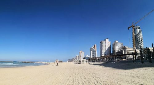 View of beach against clear blue sky