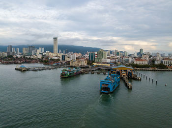 Boats in sea against buildings in city