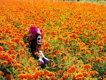 Full length of woman by flowers on field