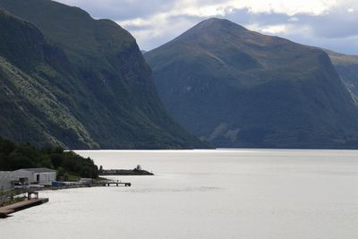 Scenic view of sea and mountains against sky