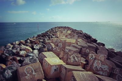 Close-up of groyne in sea against sky