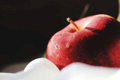 Close-up of red apple against black background