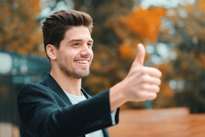 Smiling businessman showing thumbs up sign