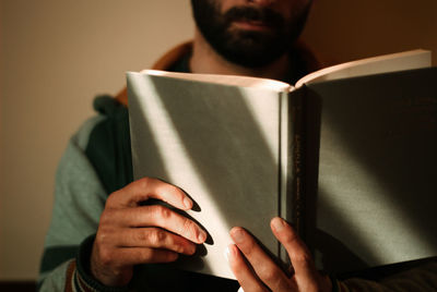 Midsection of man holding book