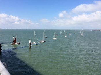 Sailboats in sea against sky