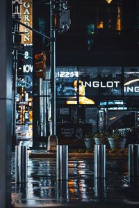 Illuminated text on street by buildings in city at night