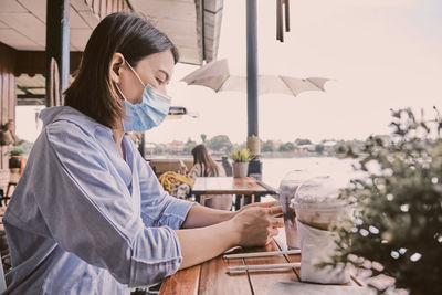 Woman using smartphone at restaurant table