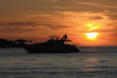 Silhouette boat in sea against sky during sunset