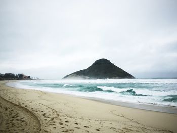 Waves rushing towards shore at praia da macumba