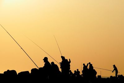 Low angle view of silhouette people at sunset