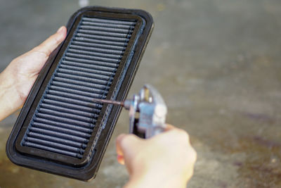 Cropped hand cleaning air filter at workshop
