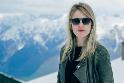 Portrait of young woman wearing sunglasses standing outdoors