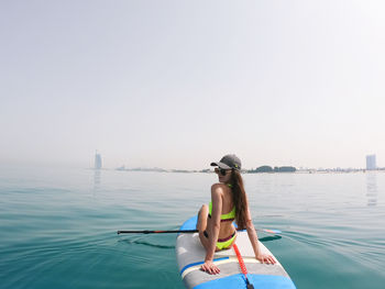 Rear view of person on sea against clear sky