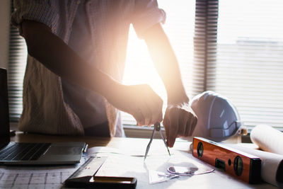 Rear view of man using mobile phone on table