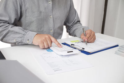 Midsection of a man sitting on table