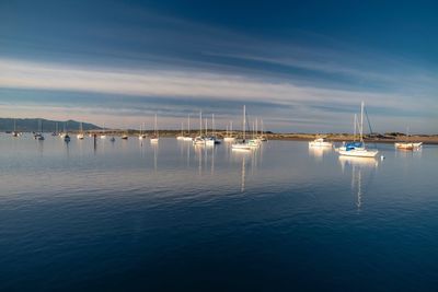 Sailboats in sea against sky