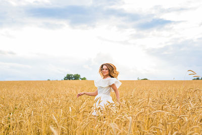 Woman standing on field against sky