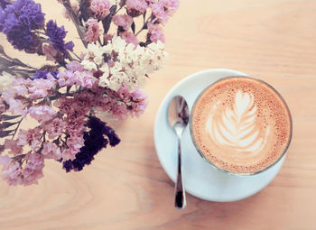 High angle view of coffee cup by flowers on table