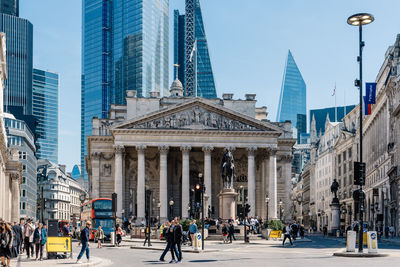 People on street amidst buildings in city