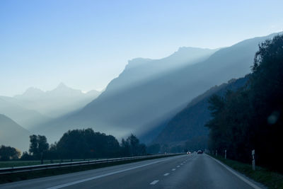 Road leading towards mountains against sky