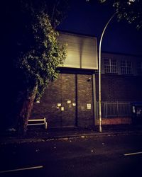 View of illuminated building by street at night