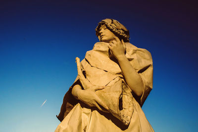 Low angle view of statue against blue sky