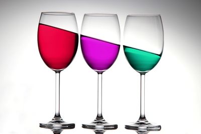 Close-up of wine glasses against white background