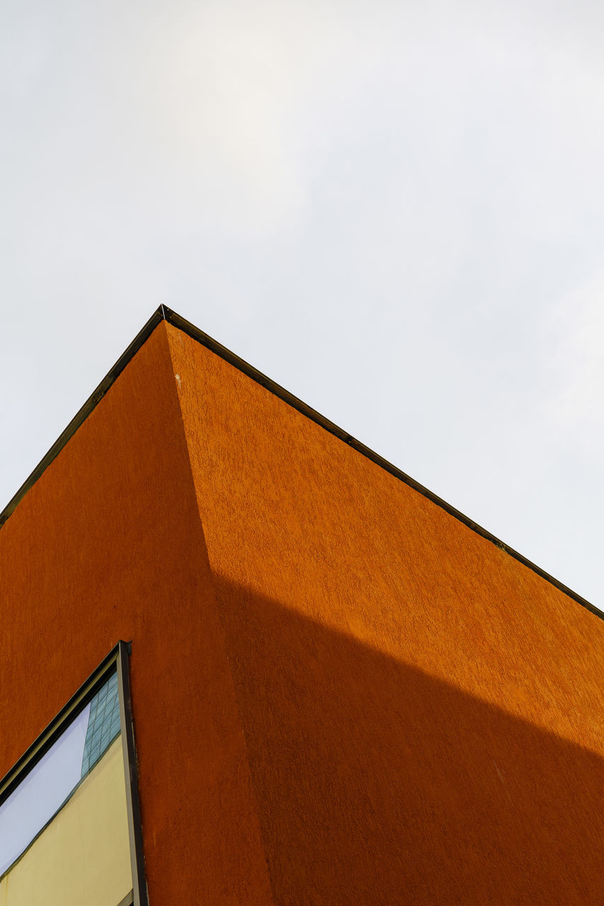 LOW ANGLE VIEW OF ORANGE BUILDING AGAINST CLEAR SKY