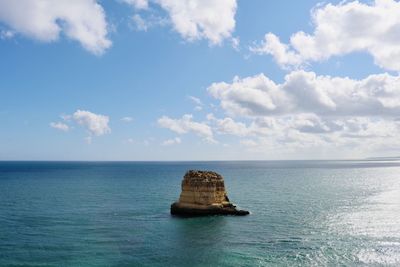 Scenic view of rock formation in sea against sky