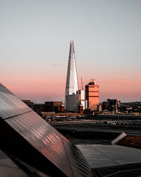 Buildings in city against sky during sunset