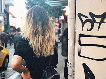 Rear view of woman walking on street in city