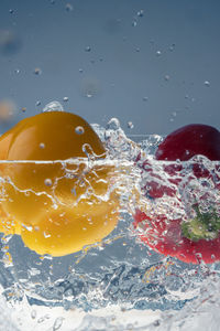 Yellow and red pepper splashing into water