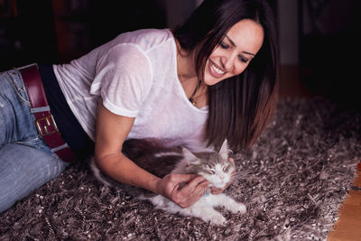 Young woman smiling while holding cat