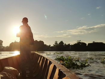 Rear view of silhouette man standing against sky during sunset