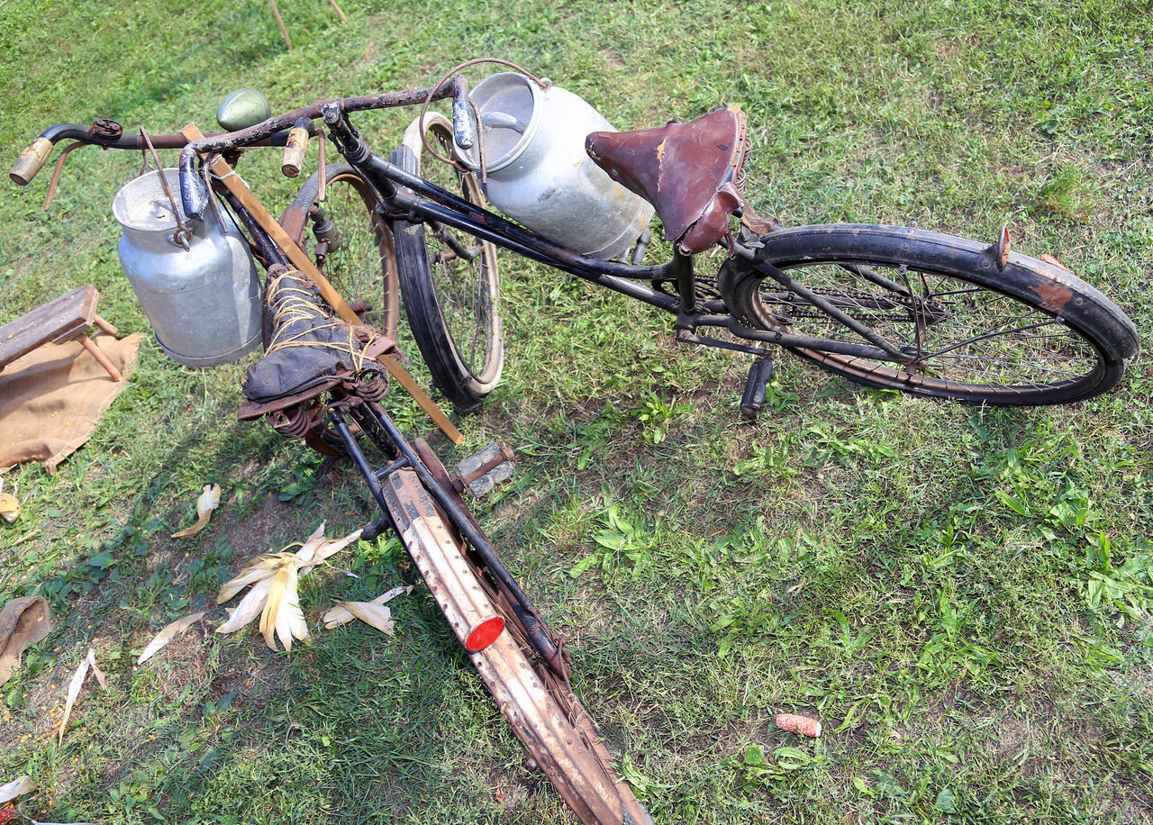 HIGH ANGLE VIEW OF ABANDONED BICYCLE IN GRASS