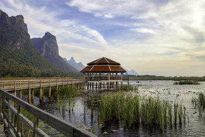 Built structure by lake against sky