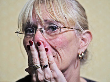 Close-up portrait of shocked woman with hand covering mouth
