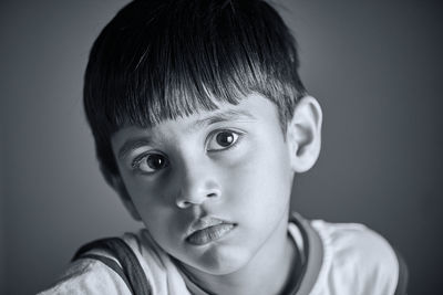 Close-up portrait of boy against gray background