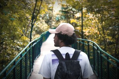 Man standing by railing against trees