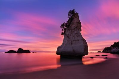 Rock formation on sea against sky during sunset