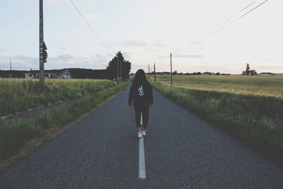 Rear view of man walking on road