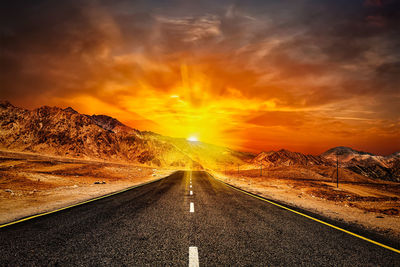 Empty road against sky during sunset