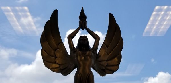 Low angle view of angel statue against sky