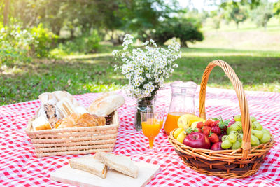 Food and drink on picnic blanket in park