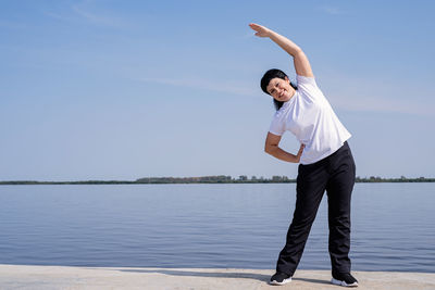 Man standing in lake against sky