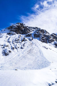 Scenic view of snowcapped mountains against blue sky