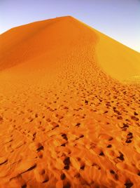 Sand dunes in desert against clear sky